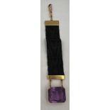 An 18 carat gold mounted amethyst watch fob on black silk grosgrain band. 13.5cm l.