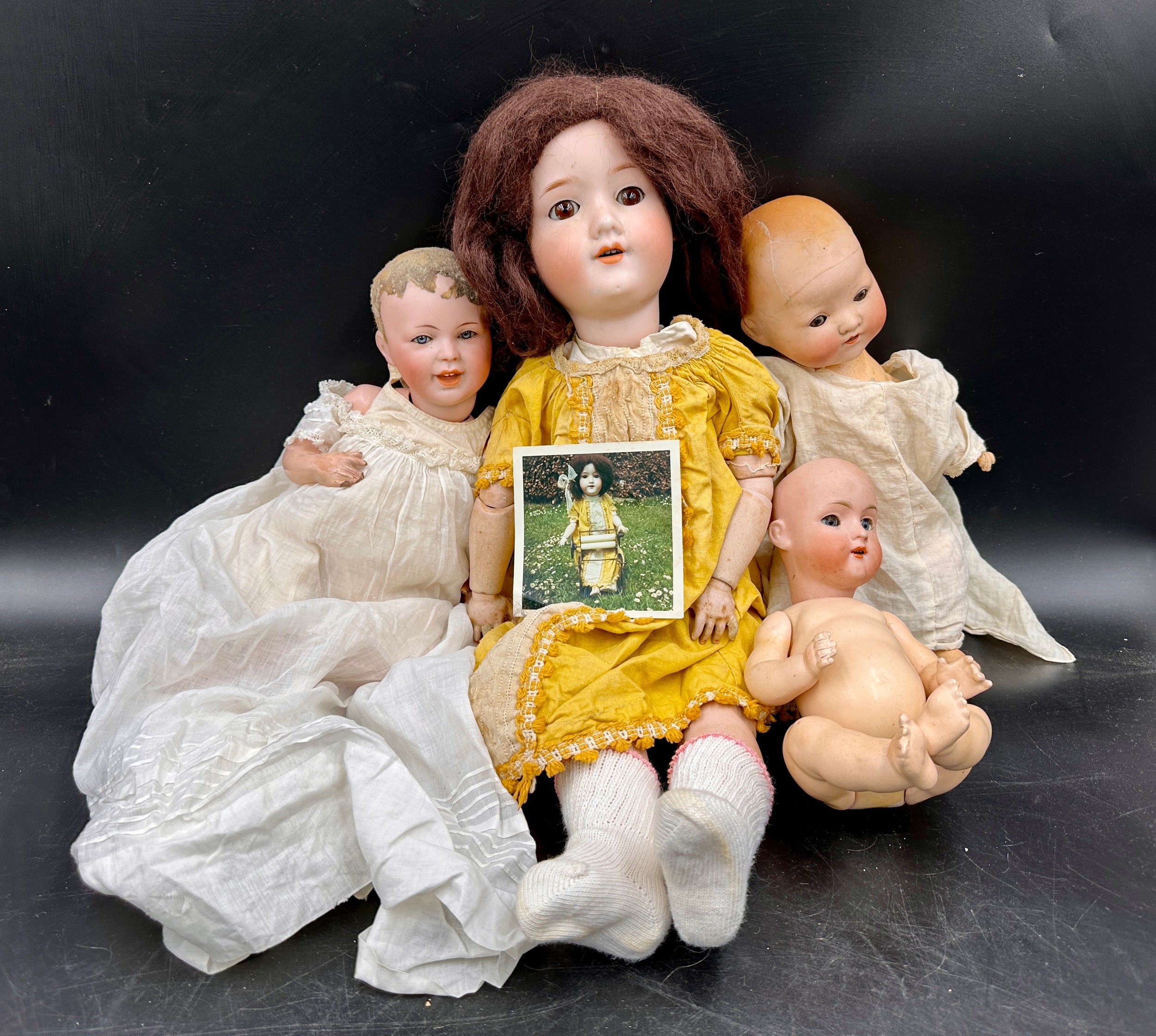 Four dolls to include an Armand Marseille Germany doll 390, A.5.M. approx. 50cm l, brown hair and