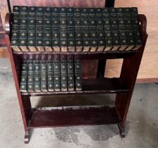 A mahogany bookcase containing volumes 1-26 of Thackeray’s works.