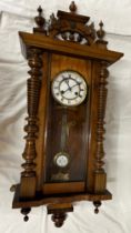 A late 19thC Vienna mahogany wall clock, with carved decoration and turned finials. Pendulum and key