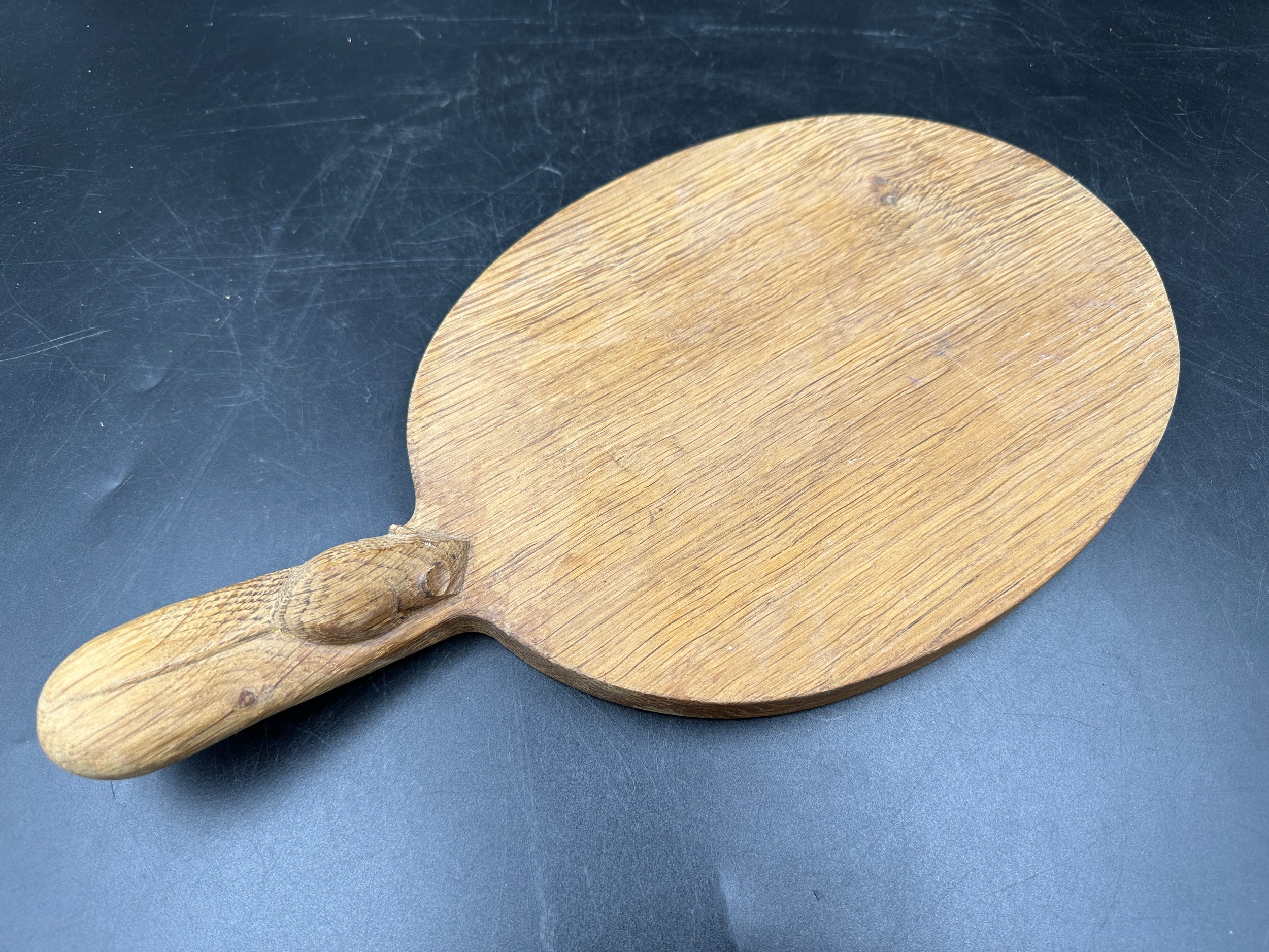Robert Thompson 'Mouseman' of Kilburn, an adzed oak cheese board of oval form with a carved mouse