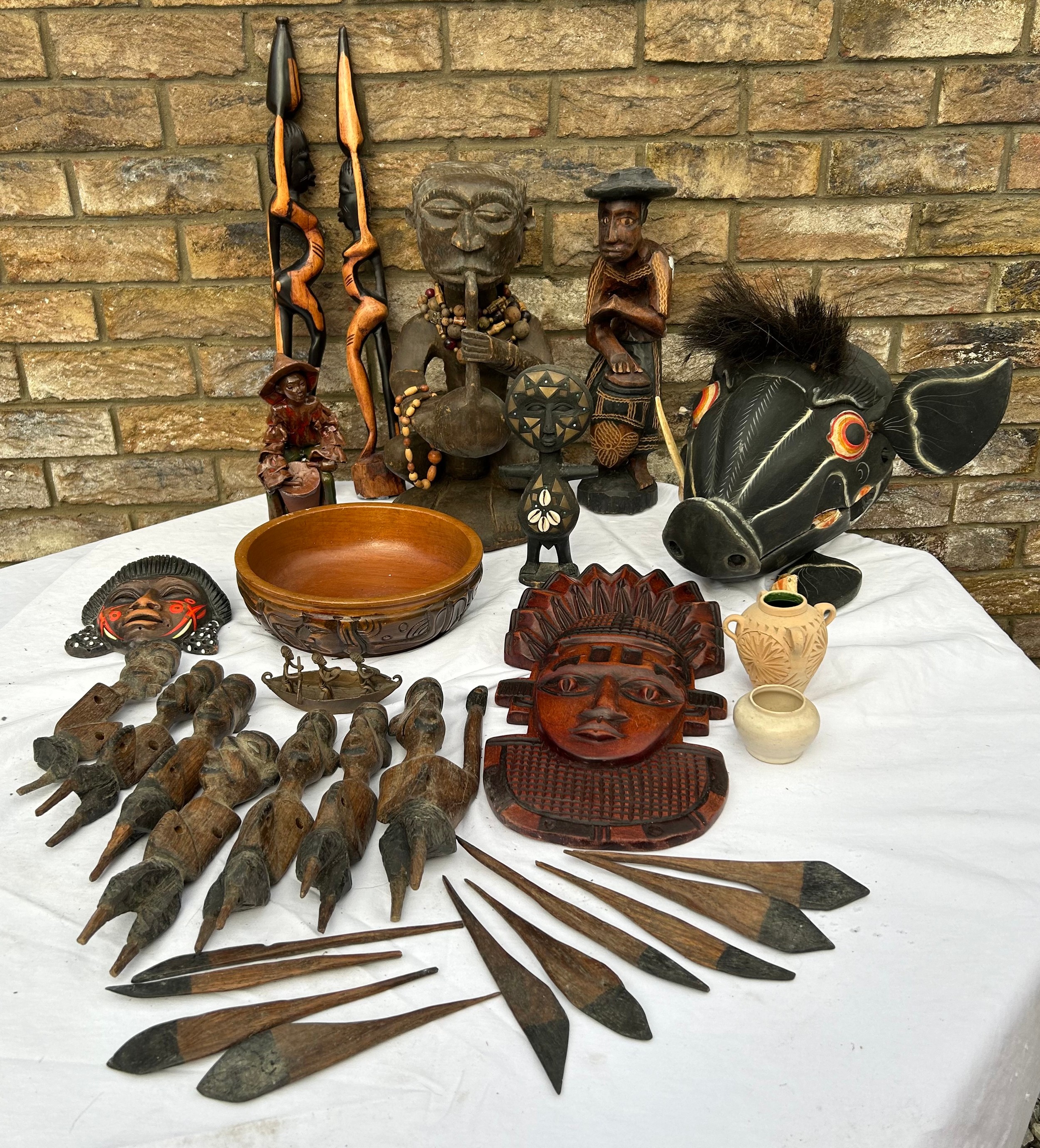 An unusual lot of tribal wooden items to include a wooden painted boar, wooden figures and mask wall
