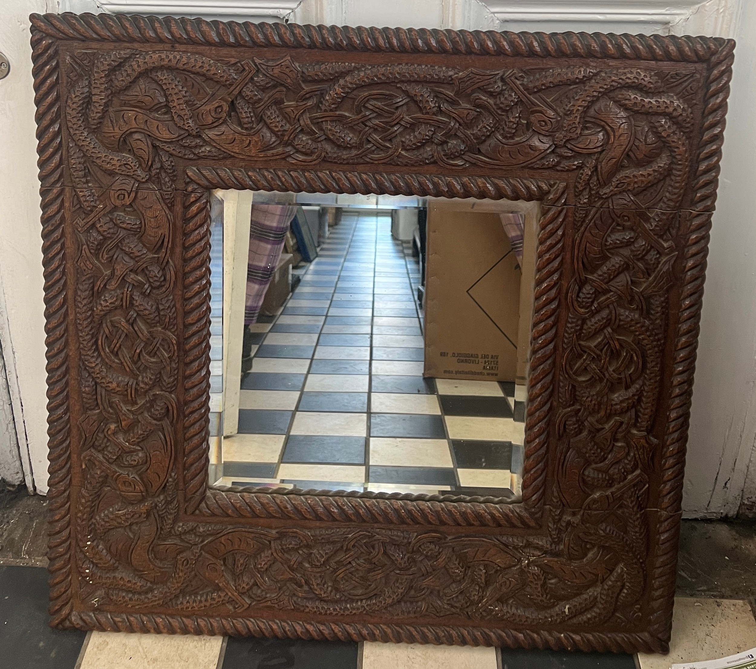 A bevel edged carved oak framed wall mirror. 68cm x 68cm.