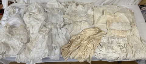 Late 19thC/early 20thC linens to include 14 christening gowns, a camisole, nightdress and silk cream