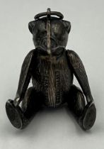 A silver pin cushion in the form of an articulated teddy. 4.5cm h. Birmingham 1909, maker HV