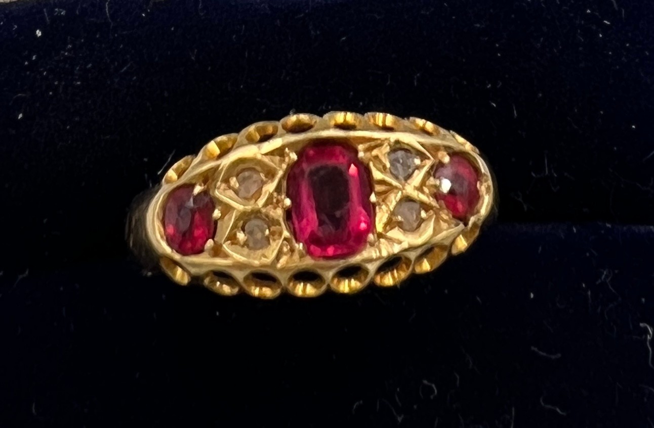 A 18 carat gold ring set with rubies and diamonds, Size L. Weight 1.7gm.