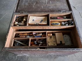 A large vintage pine chest filled with an assortment of tools.