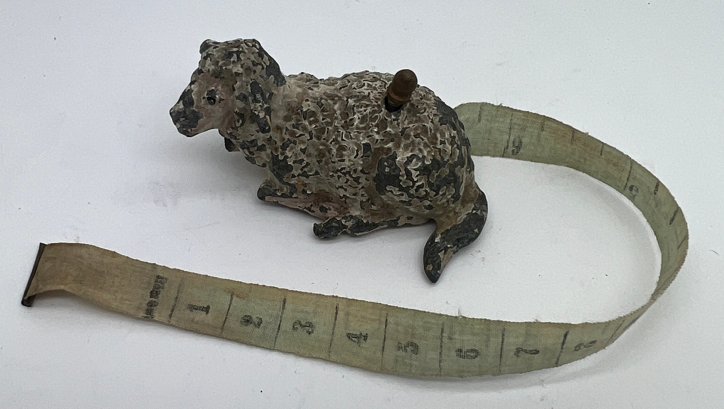 An early 20thC metal sheep tape measure. 5cm l. Measures centimetres and inches. - Image 2 of 5