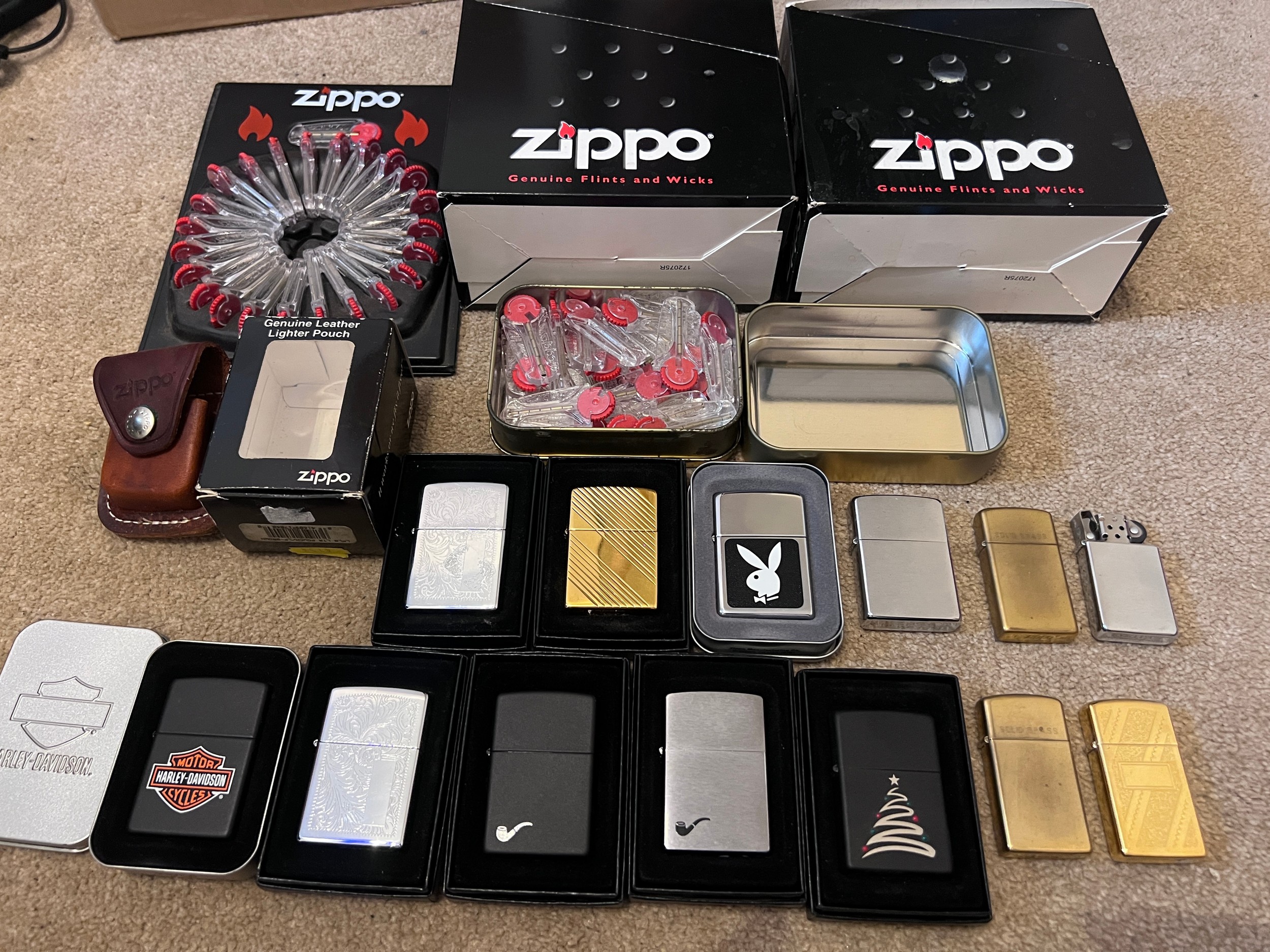 A large collection of mostly boxed Zippo lighters to include Harley Davidson, Bunny, older brass