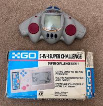 A Go 5-in-1 super challenge handheld game console together with a Radioshack handheld shooting game.