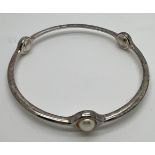 A Georg Jensen 473 sterling silver and pearl bangle. Interior measurement 6.5cm approximately.