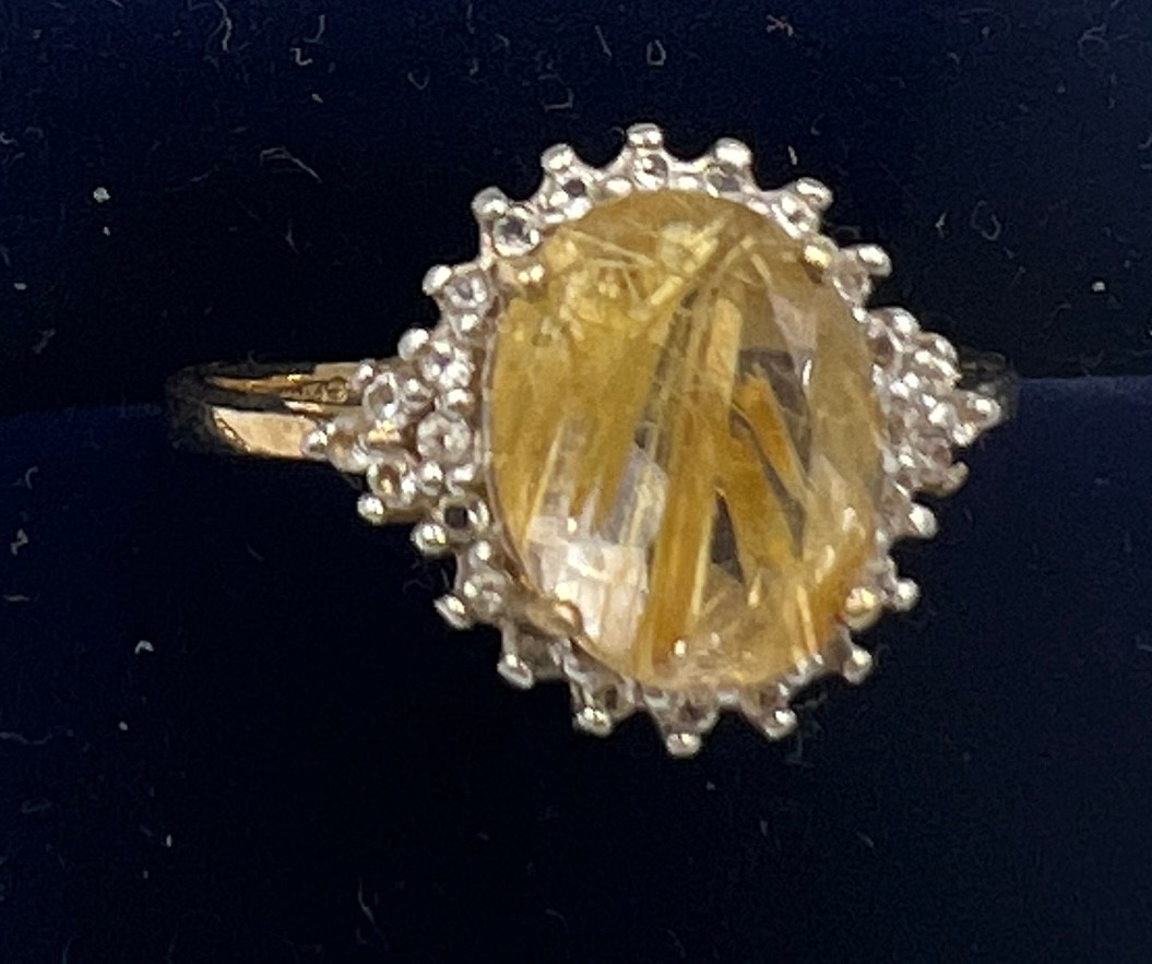 A 9 carat gold ring set with yellow and clear stones. Size P. Weight 2.3gm.