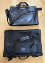 A Tumi black leather briefcase/laptop bag together with a black Tumi suit carrier with leather