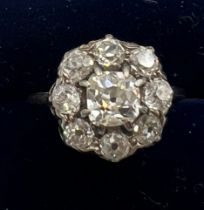 An old cut diamond cluster ring. The central stone surrounded by eight smaller diamonds. Size G.