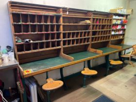 A vintage post office sorting bench with pigeon holes and seats with two metal pedestals. 384cm l
