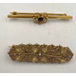 Two 9 carat gold bar brooches, one set with seed pearls, the other with central red stone. Total