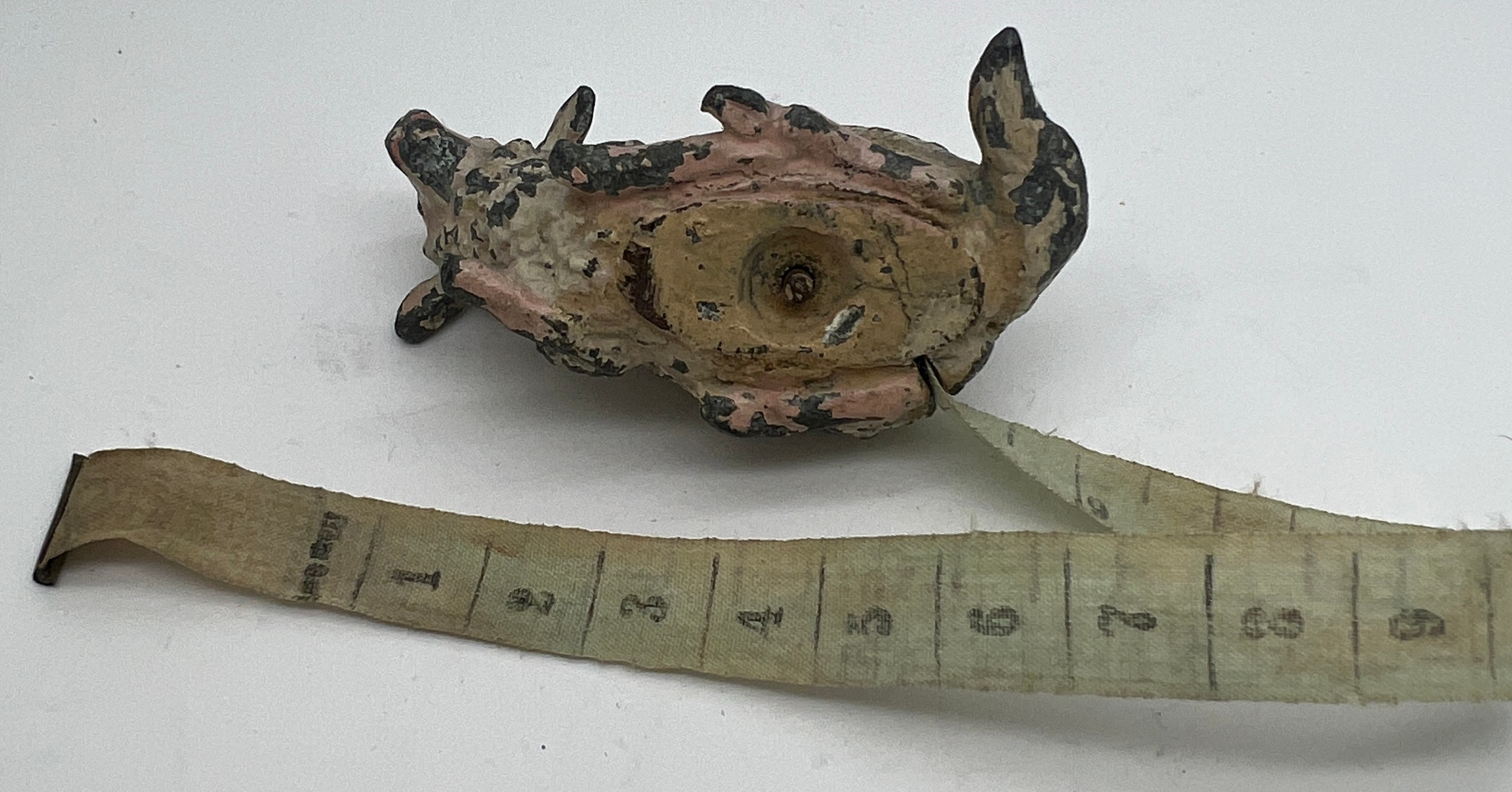 An early 20thC metal sheep tape measure. 5cm l. Measures centimetres and inches. - Image 3 of 5