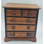 A 19thC pine miniature chest of two short over three long drawers. 38cm h x 35cm w x 21cm d. With