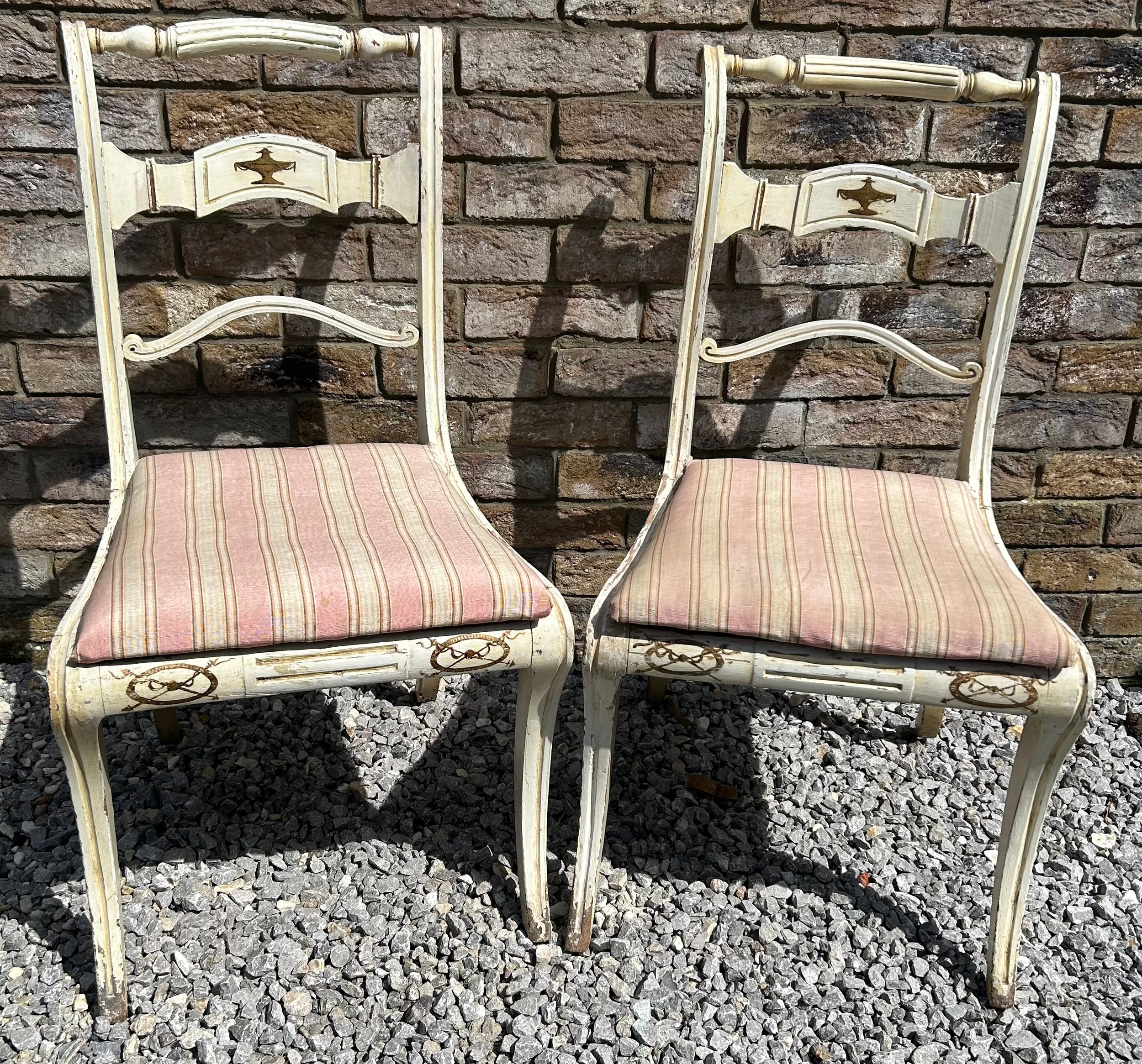 A pair of early 19thC bar backed painted chairs with sabre legs to the front.