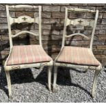 A pair of early 19thC bar backed painted chairs with sabre legs to the front.
