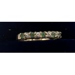 A 9 carat gold ring set with green and clear stones. Size O. Weight 1.6gm.