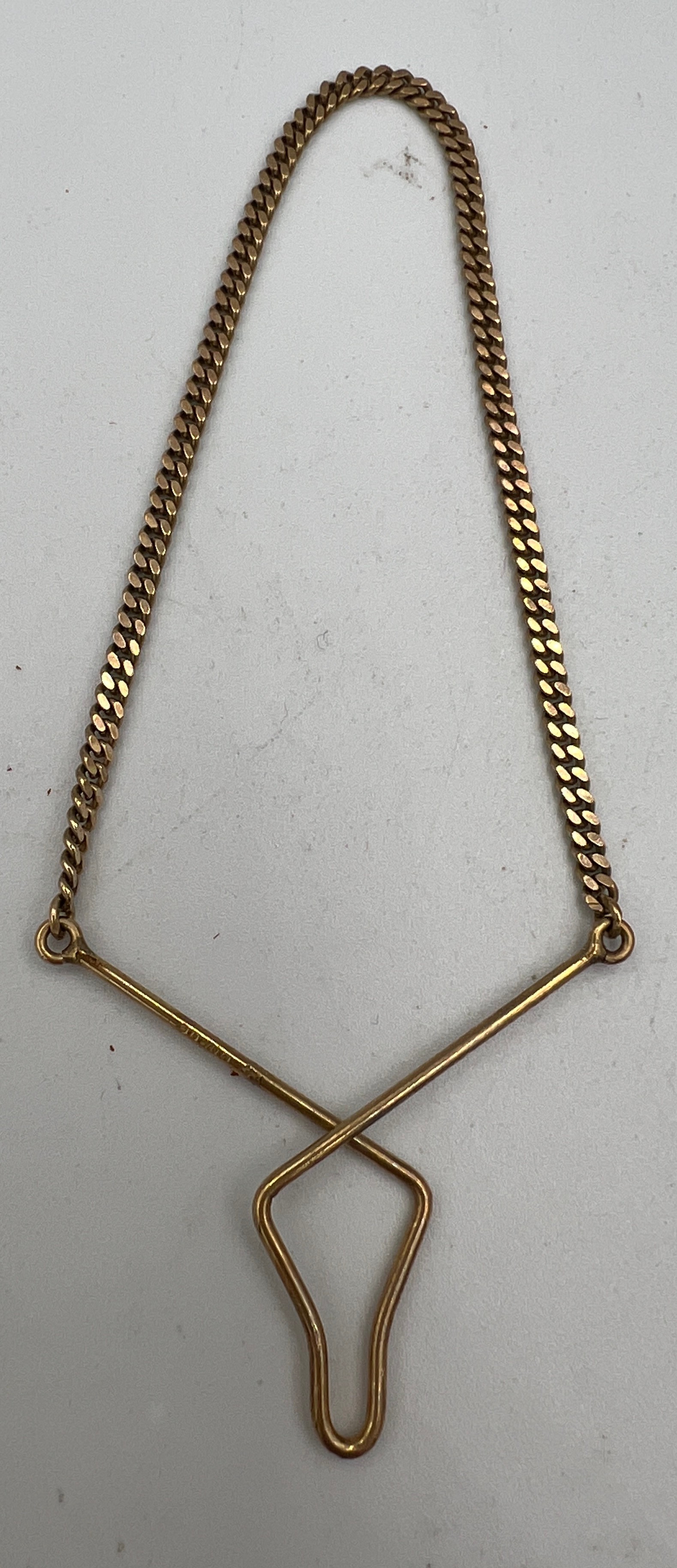 A nine carat gold tie clip and chain. Weight 3gm.