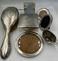 A quantity of silver to include frames, cigarette box, salt and hairbrush.