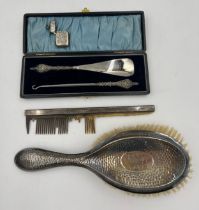 A boxed silver handled shoe horn and button hook, a silver backed hairbrush and comb together with a