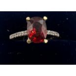 A 9 carat gold ring set with red and clear stones. Size O. Weight 2.4gm.