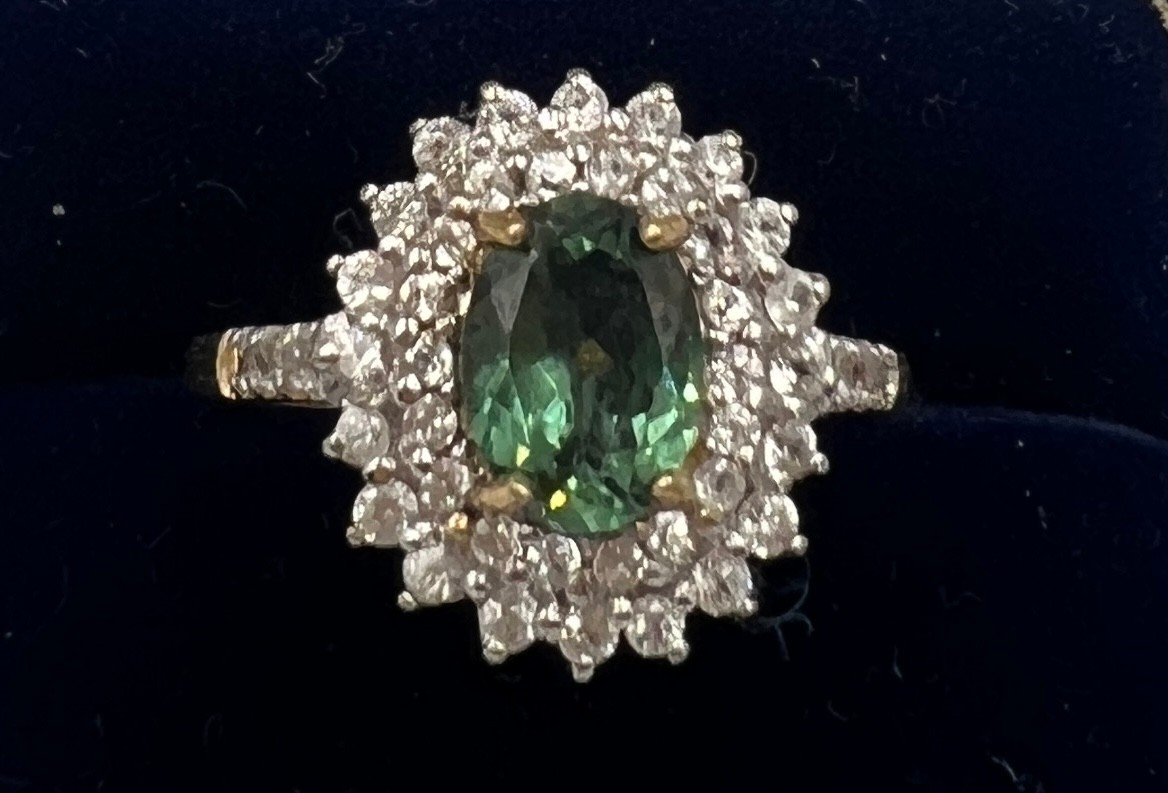 A 9 carat gold ring set with green and clear stones. Size P. Weight 3gm.