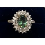 A 9 carat gold ring set with green and clear stones. Size P. Weight 3gm.