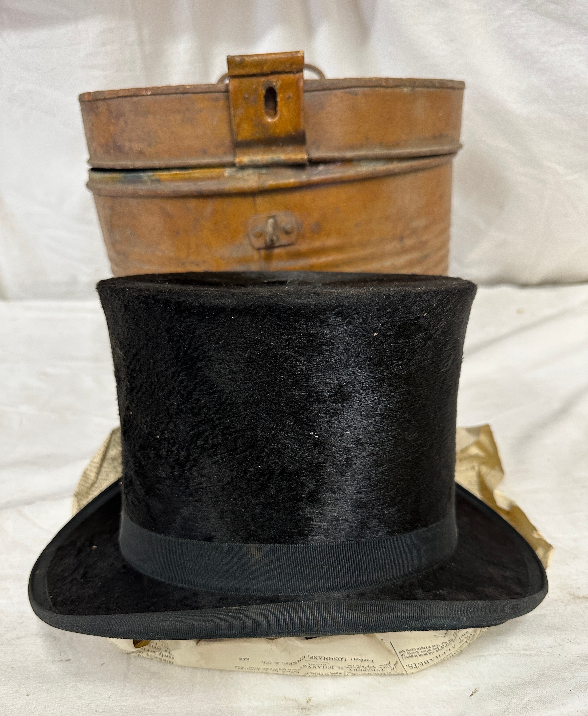 A silk top hat by J Robinson & Sons, Driffield. Approx. circumference 58cm, in a metal hat box.