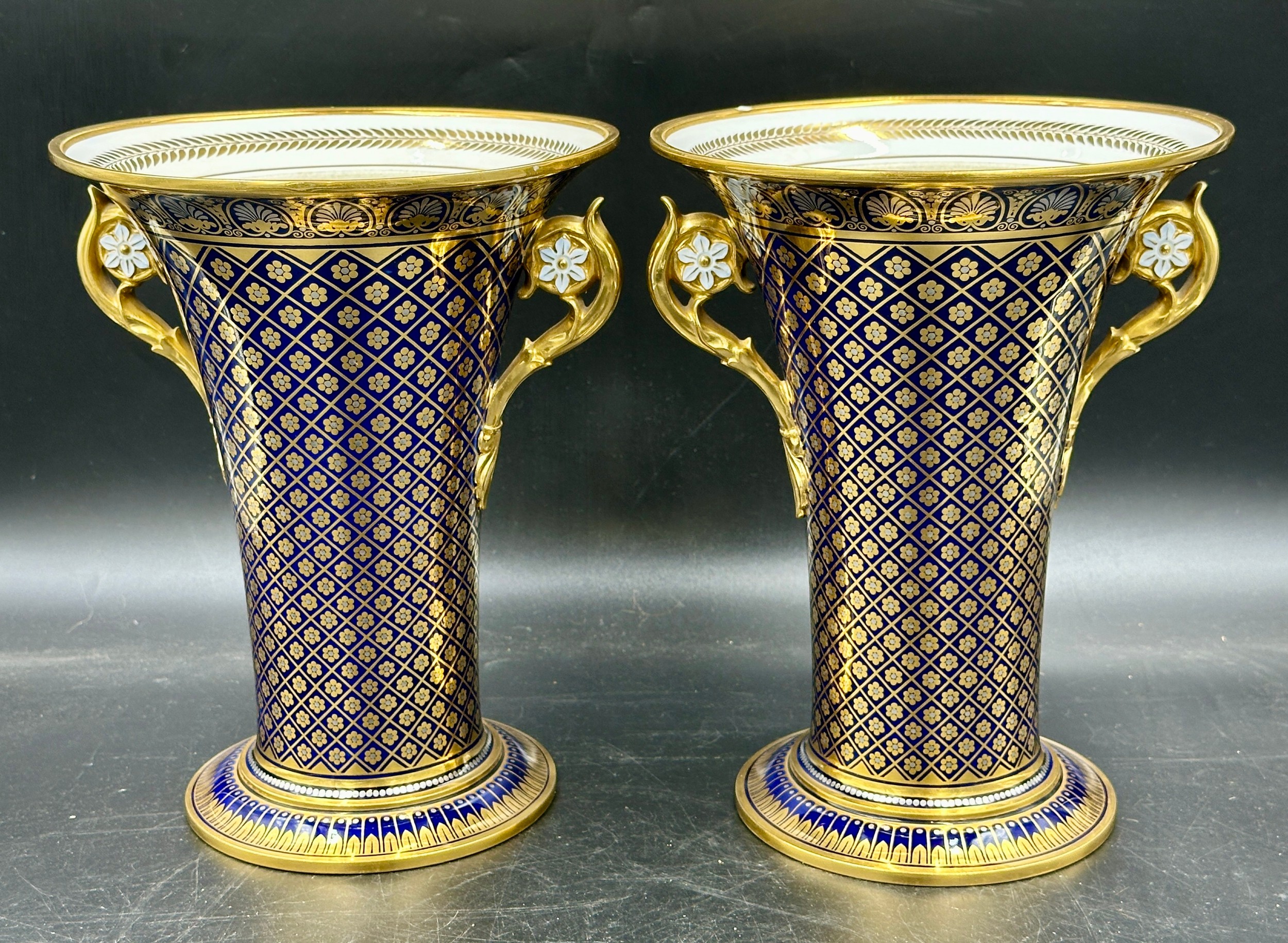 Two twin handled vases with gilt decoration on a blue ground. Marks to base - Sevres 1838, one with