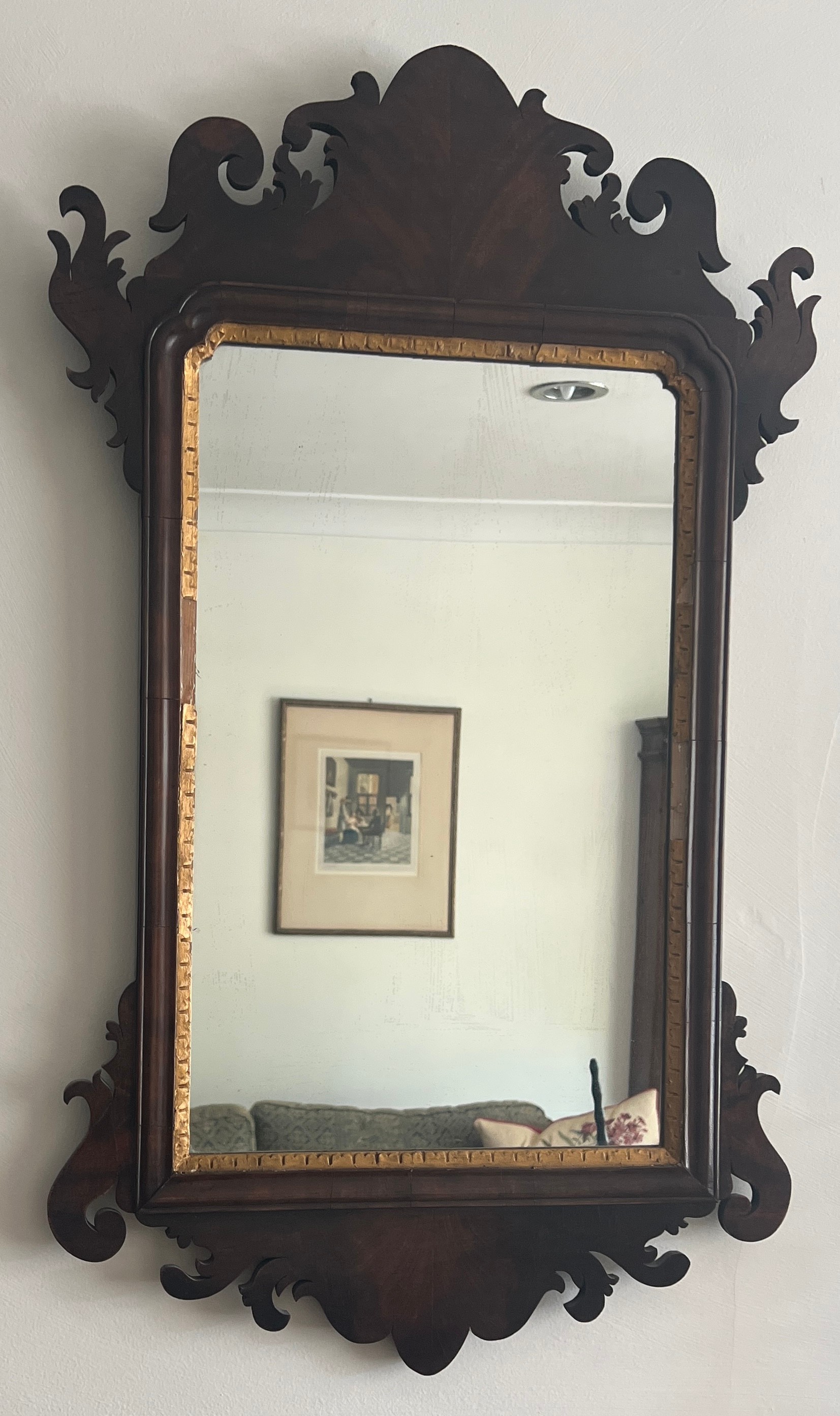 A mahogany and gilt fretted wall mirror. 78cm x 46cm.
