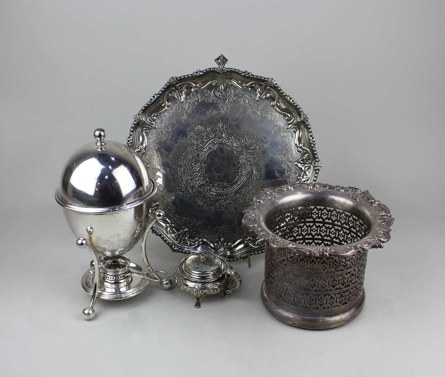 A collection of silver-plated items to include a wine coaster, salver, and an egg coddler mustard