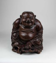 A carved hardwood figure of a laughing Buddha 28.5cm high