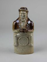 A 19th century Derbyshire brown stoneware reform flask in the form of a drinker sitting astride a