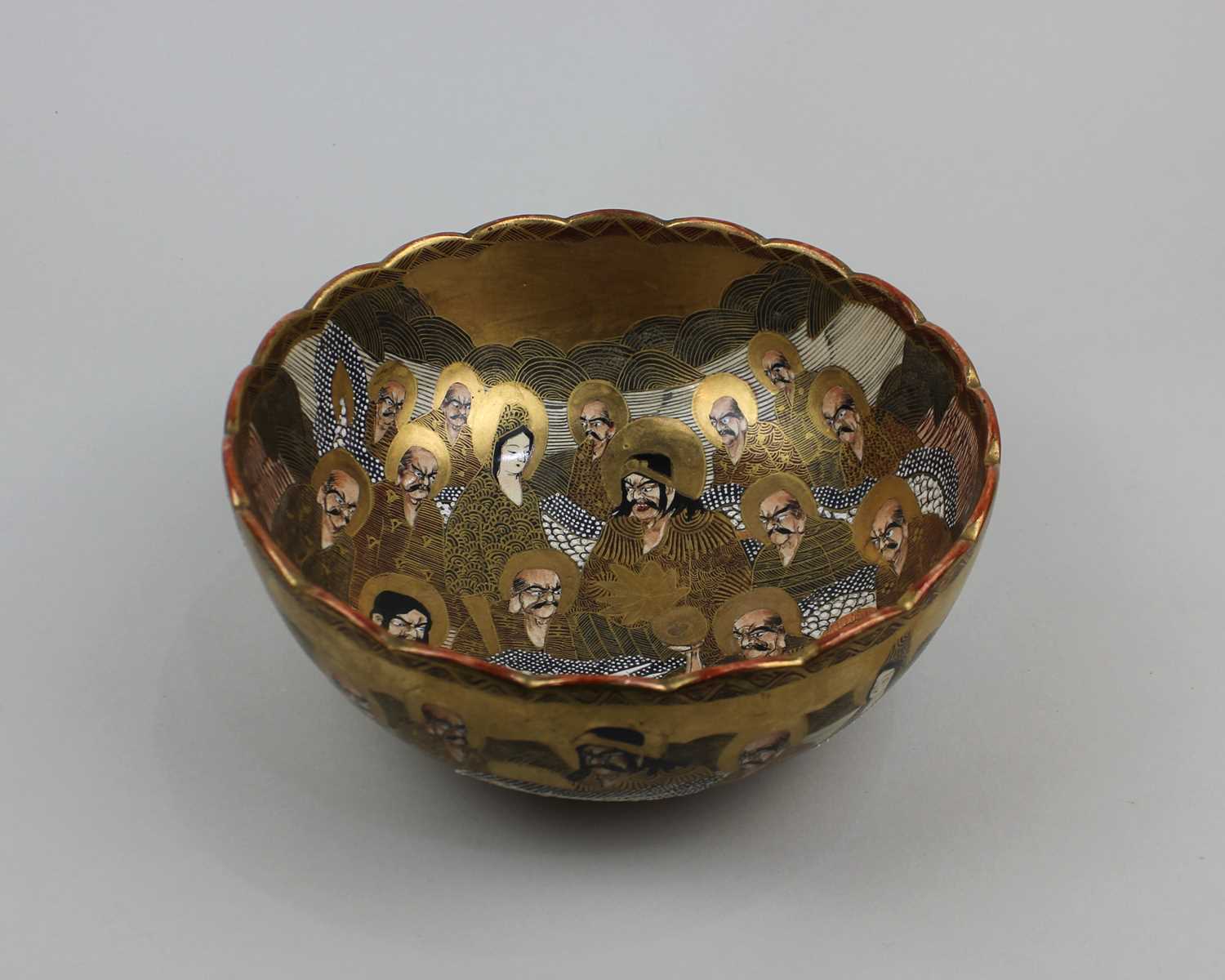 A Japanese Satsuma ware bowl with figural decoration and git embellishments, mark to base 21.5cm