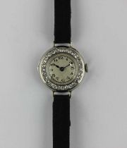 A ladies platinum cased and diamond set circular cased dress wristwatch, the jewelled lever movement