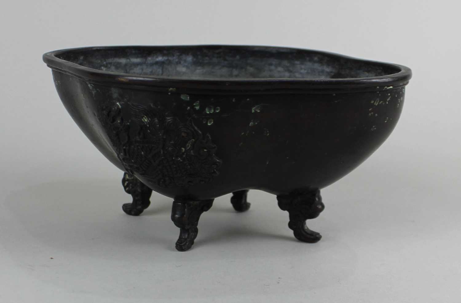 A Chinese bronze lozenge shaped censer decorated in light relief with two ho-ho birds, on four