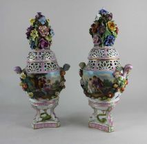 A pair of German porcelain Carl Thieme Potschappel pedestal vases and covers, both painted with
