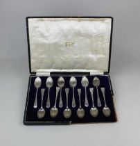 A cased set of twelve George IV silver teaspoons with a shell bowl, bright cut engraved pattern