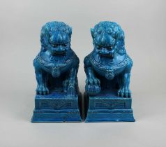 A pair of turquoise glazed ceramic Fo dogs seated on a rectangular plinth, 28cm (a/f)