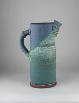 A 20th century studio pottery tall jug, blue glazed, with impressed maker's marks to side 38.5cm