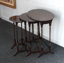 A nest of three mahogany side tables two oval and one circular with gadroon carved borders, 56cm