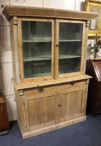 A pine cabinet top with two glazed doors enclosing shelves on base with two drawers and cupboards,