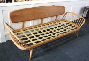 An Ercol 'surfboard' settee with removable solid back and spindle sides (a/f without cushions and