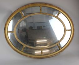 A 20th century Adam style giltwood and gesso framed oval wall mirror, the central bevelled mirror