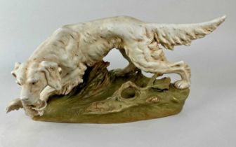 An early 20th century Royal Dux porcelain model of a Gun Dog with game bird on naturalistic base,