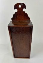 A George III oak candle box, possibly Welsh. Having a shaped raised back with suspension hole, and